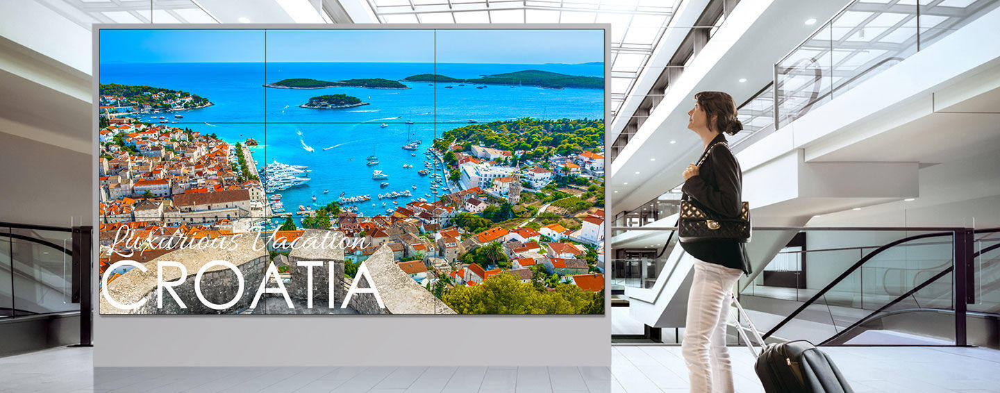 Large video wall displaying a scenic view of a Croatian coastline in a modern building lobby.