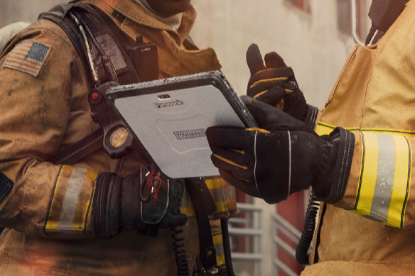 Two firefighters discussing while holding a tablet