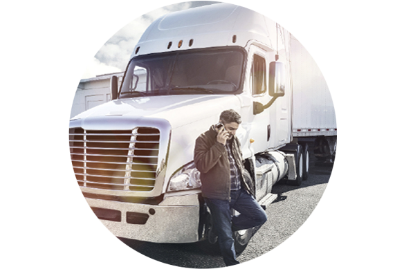 Man leaning on white semi truck while on the phone