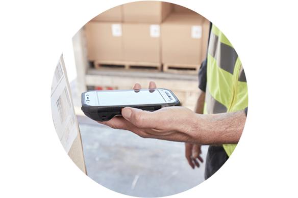 Man with high visibility vest using handheld device to scan boxes